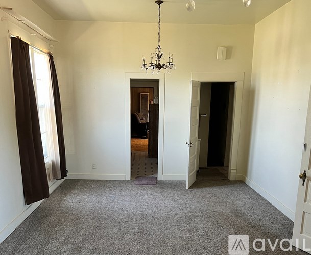 A room with a chandelier and a carpeted floor.