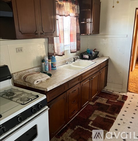 A kitchen with a white stove and brown cabinets.