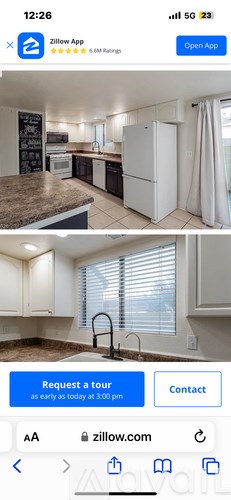 A kitchen with a refrigerator, sink, and cabinets is shown.