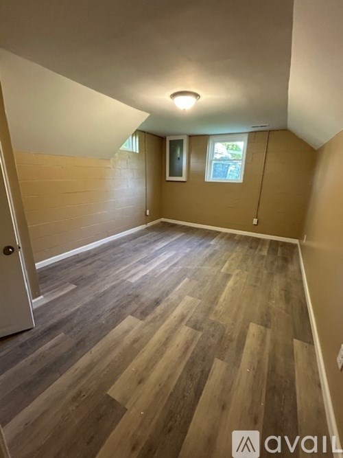 A room with wooden flooring and a white door.