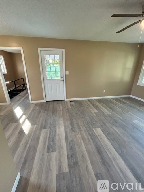 A room with wooden flooring and a white door.