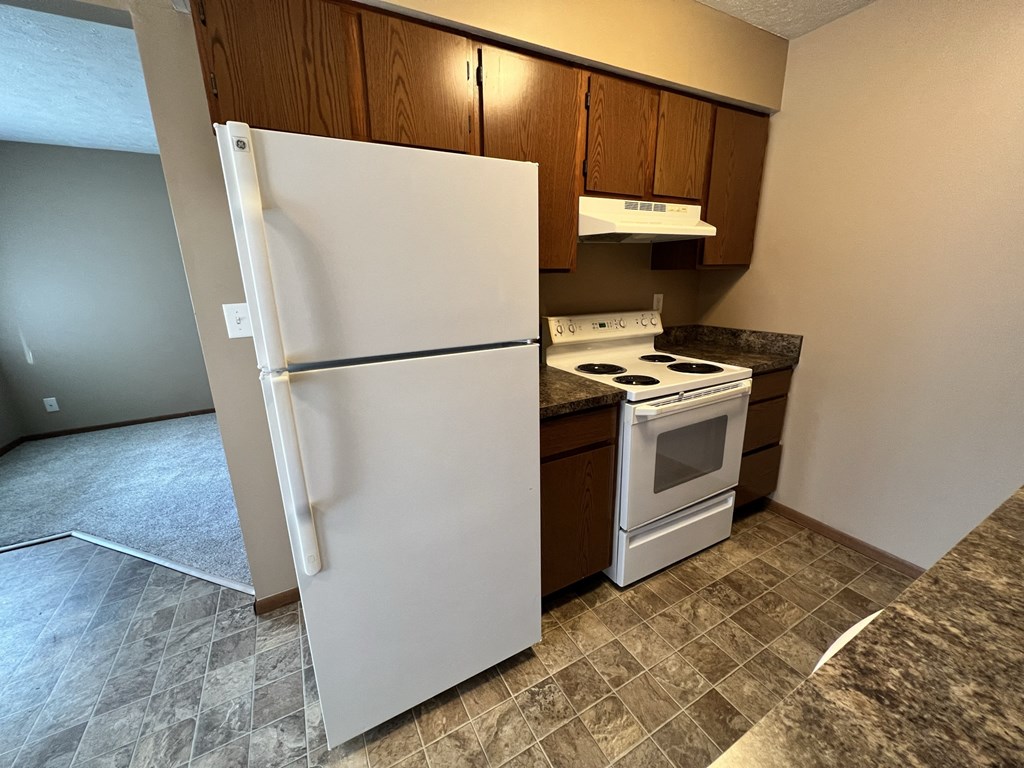 a kitchen with a refrigerator and a stove and