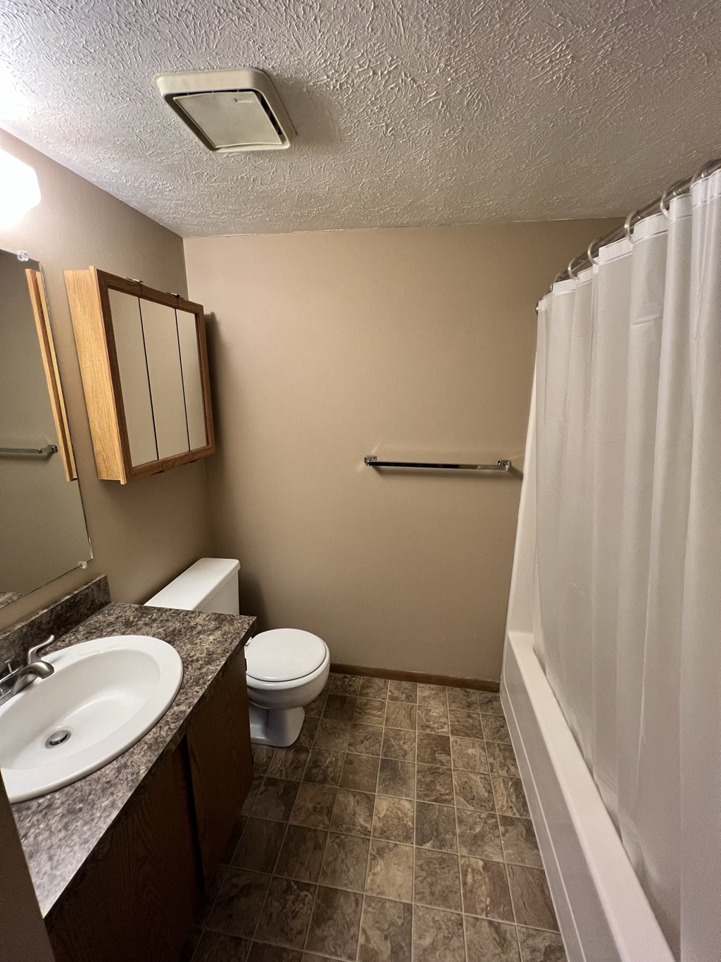 a bathroom with a toilet and a sink and a shower