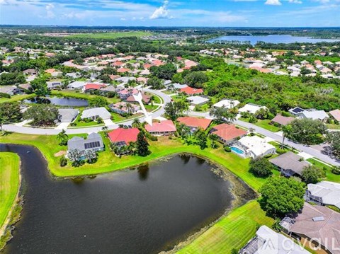 A bird's eye view of a residential area with a lake in the foreground.