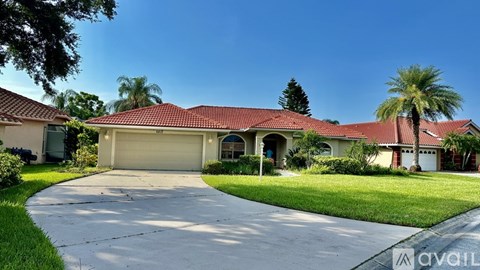 A house with a red roof and a driveway in front.