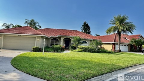 A house with a red roof and a garage door is for sale.