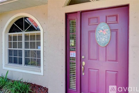 A purple door with a circular decoration in the middle.