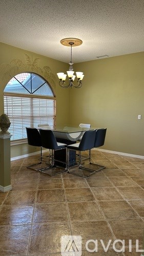 A dining room with a table and chairs.