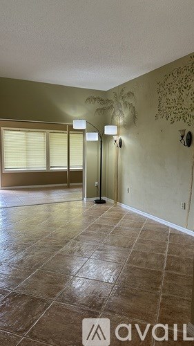 A room with a tiled floor and a wall with a leaf design.