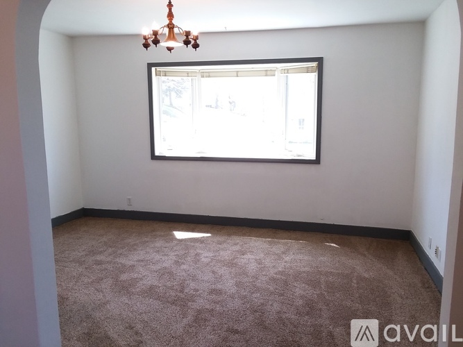 A room with a carpeted floor and a window.