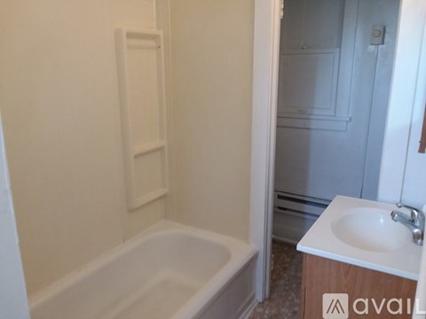 A white bathroom with a tub and sink.