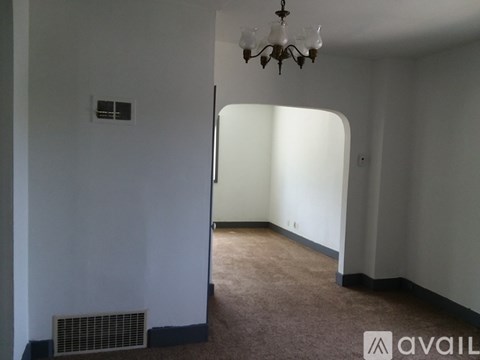 A room with a chandelier and a wall-mounted air vent.