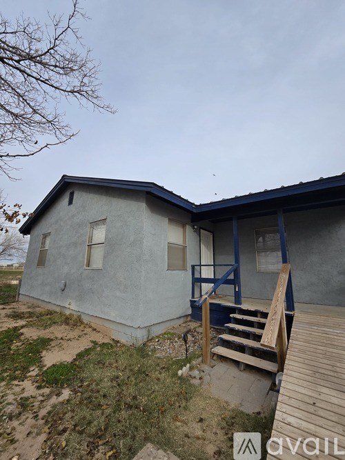 A small house with a blue roof and a wooden deck.