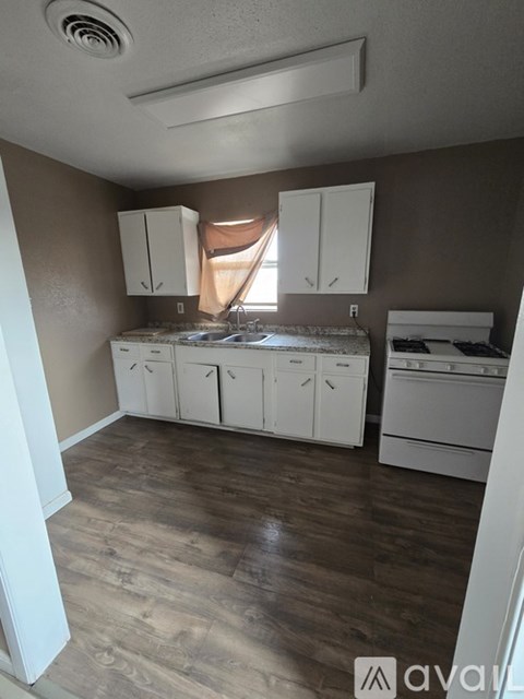 A kitchen with white cabinets and a washing machine.