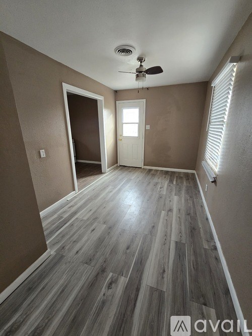 A room with wooden flooring and a ceiling fan.
