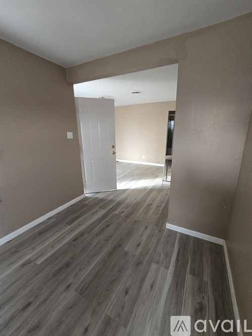 A room with wooden flooring and a white door.