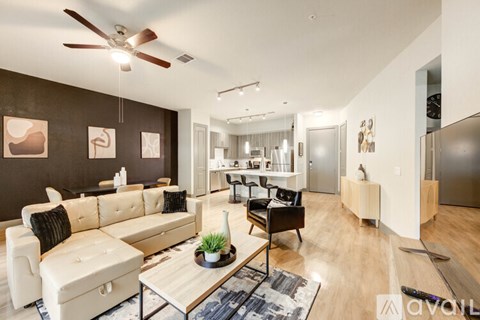 A living room with a white sofa and a black chair.