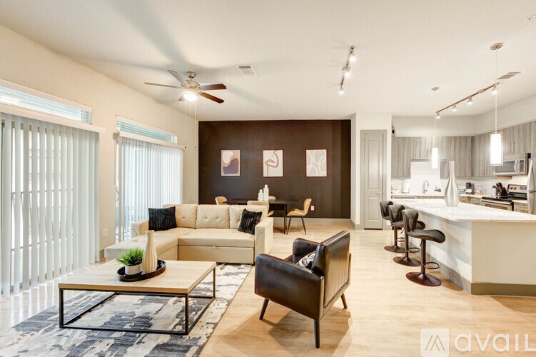 A living room with a white sofa, a black chair, and a coffee table.