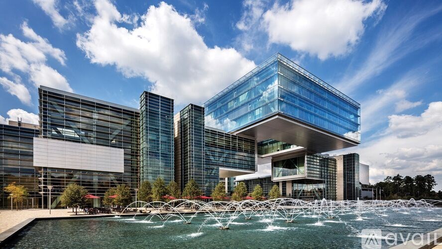 A modern glass building with a pool in front.
