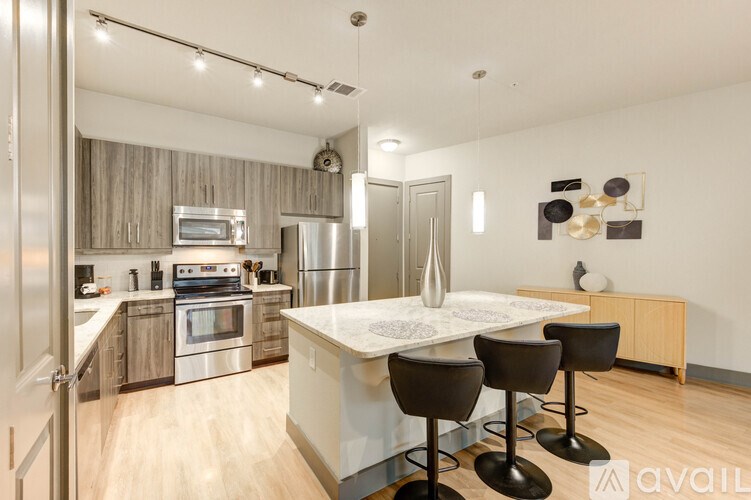 A modern kitchen with a center island and bar stools.