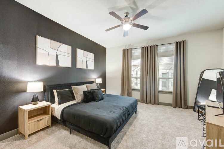 A bedroom with a large bed and a ceiling fan.