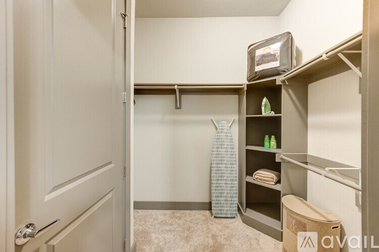 A small, empty room with a door and a shelf with a few items on it.