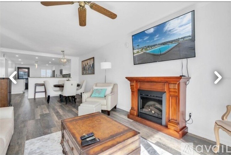 A living room with a fireplace and a television mounted above it.