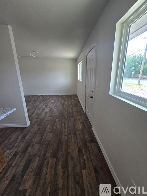 A room with wooden flooring and a window.