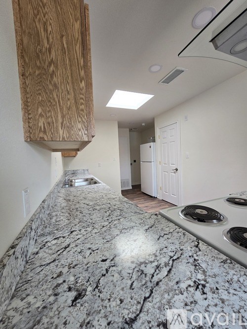A kitchen with a granite countertop and a wooden cabinet.