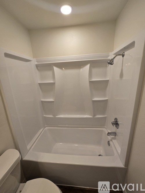 A white bathroom with a toilet and a bathtub.