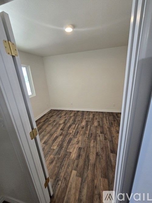 A room with wooden flooring and a white door.