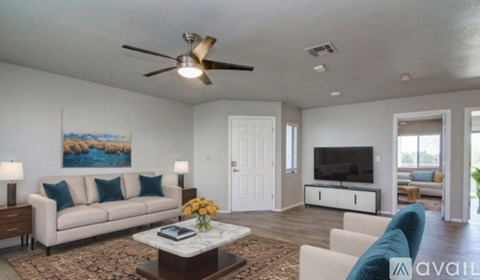 A living room with a white couch, a coffee table, and a painting on the wall.