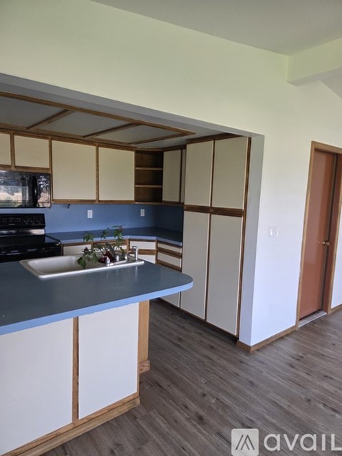 A kitchen with a blue countertop and white cabinets.