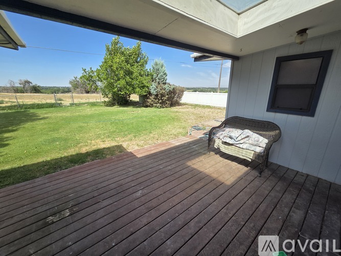 A wooden deck with a chair and a table on it.