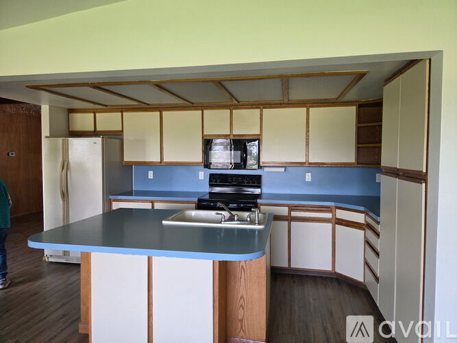 A kitchen with a blue counter and wooden cabinets.
