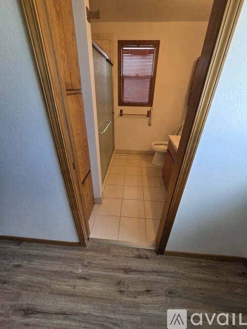 A bathroom with a toilet, sink, and window.