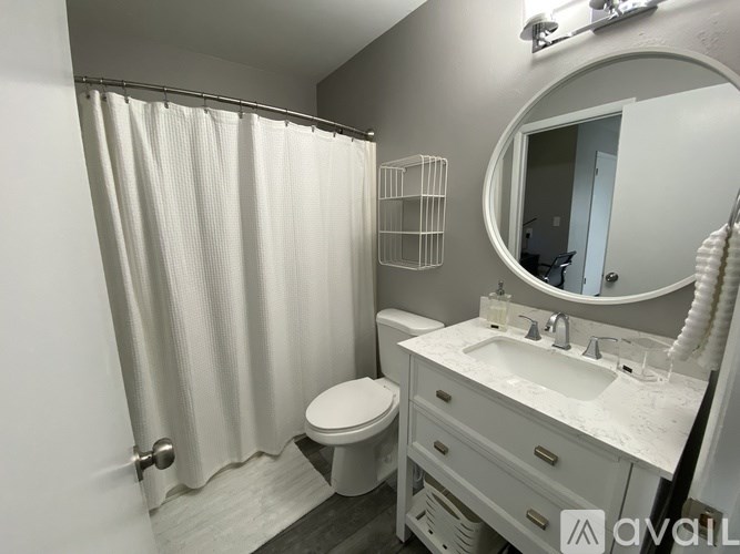 A bathroom with a toilet, sink, and shower curtain.