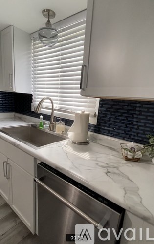 A kitchen with a marble countertop and stainless steel appliances.