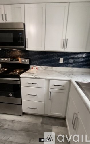 A kitchen with white cabinets and a black stove top.