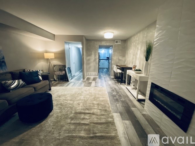 A modern living room with a grey sofa and a wooden floor.