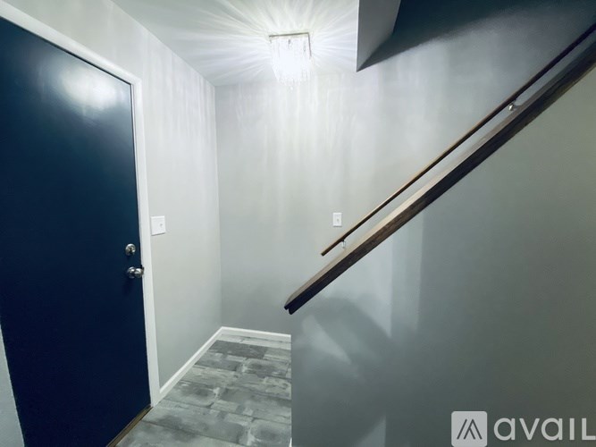 A hallway with a blue door and a light on the ceiling.