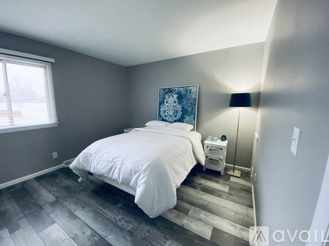 A bedroom with a bed, nightstand, and lamp.