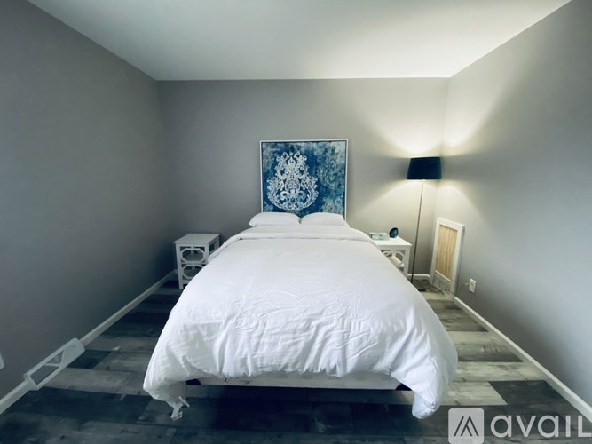 A bedroom with a white bed and a blue patterned headboard.