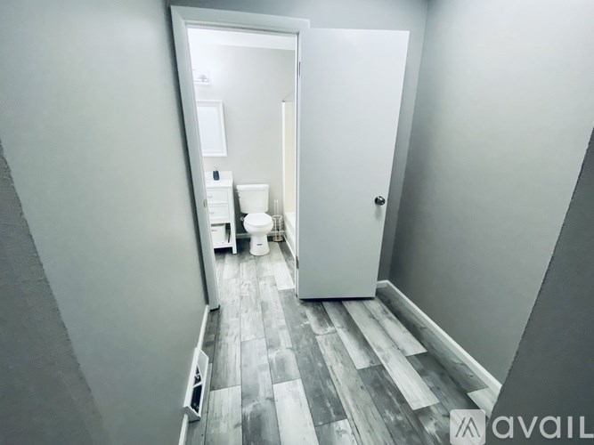 A bathroom with a toilet, sink, and mirror.