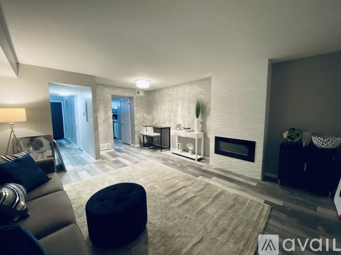 A modern living room with a fireplace and a large mirror on the wall.