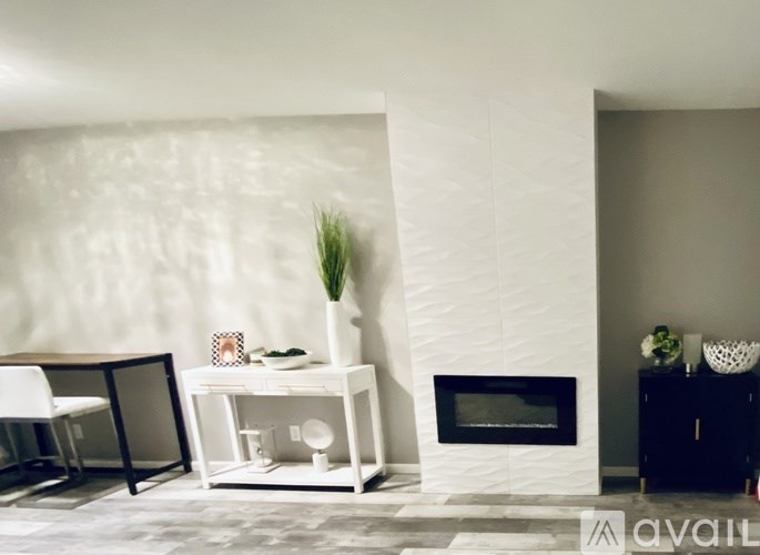 A white fireplace with a plant on top of a white shelf.
