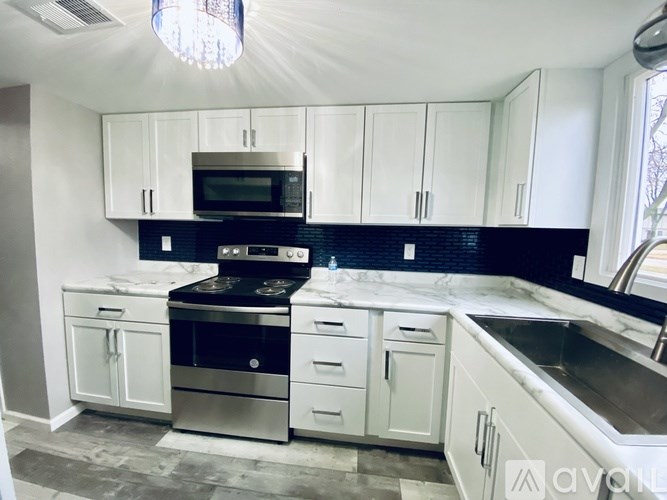 A kitchen with white cabinets and a black stove top oven.
