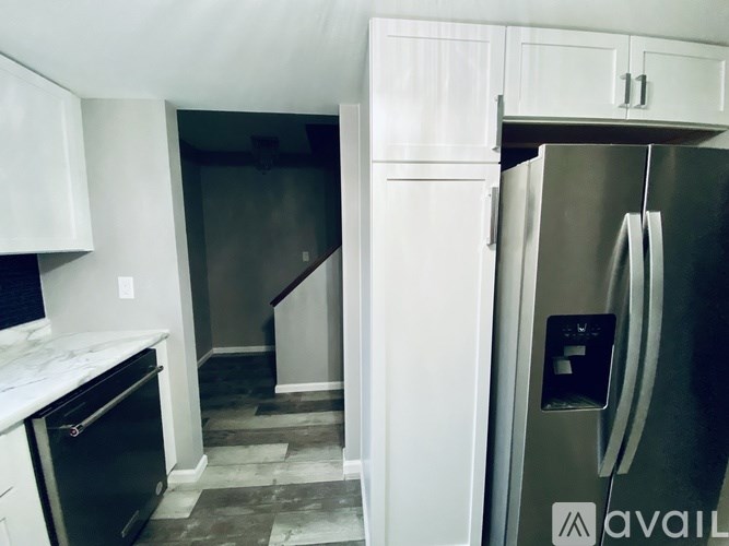 A kitchen with a refrigerator and a stove top oven.