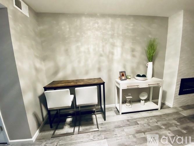 A room with a table and chairs and a shelf with items on it.