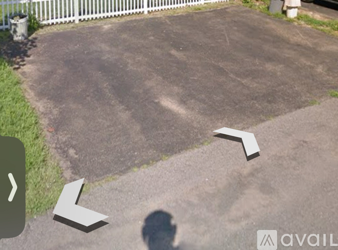 A shadow of a person is cast on a driveway.